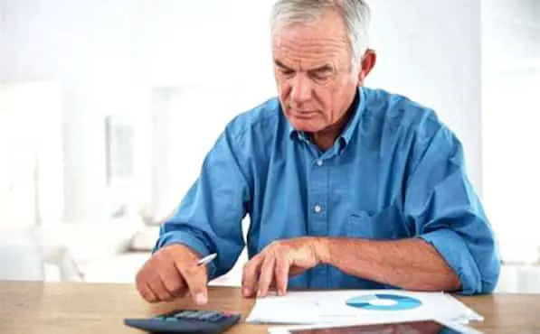 Retraité en train de faire des calculs. 