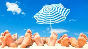 Pieds humains sous un parasol