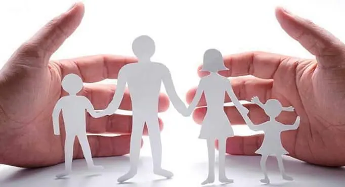 Deux mains devant des silhouettes découpées en papier