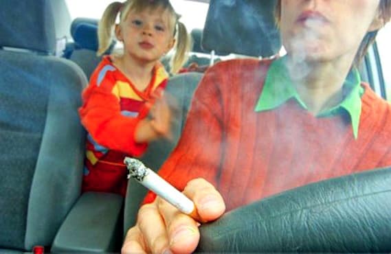 Adulte fumant devant son enfant