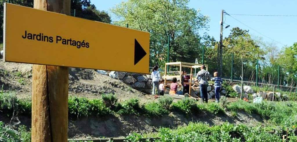 un panneau indiquant la direction du jardin partagé
