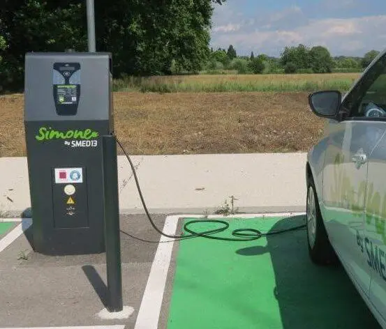 une borne de recharge électrique reliée à une voiture