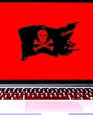 Un ordinateur portable sur lequel s'affiche un drapeau de pirate noir sur fond rouge. La région Grand-Est a dernièrement subi une attaque informatique d'envergure.
