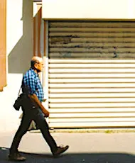 Un homme qui passe devant un commerce fermé. "<yoastmark
