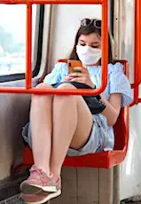 Une jeune femme masquée assise dans le métro. Les masques obligatoires dans les lieux publics clos sont désormais la règle.
