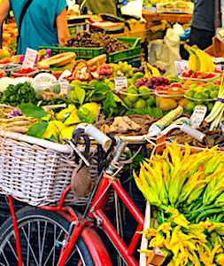 un vélo devant un étal de fruits et des client pour une adoption des circuits courts
