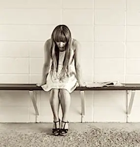 Une jeune femme prostrée sur un banc Pour l'exécutif, les risques de suicide chez les jeunes sont devenus un sujet d’inquiétude.