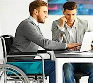 Un travailleur en fauteuil qui collabore avec un travailleur valide avec une aide aux ESAT 