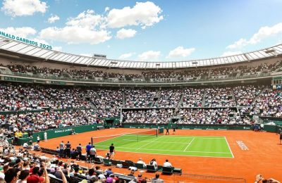 Terrain de tennis rouge avec joueurs à Roland Garros.