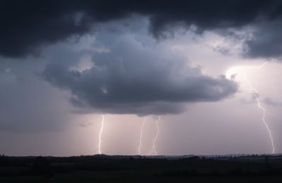 Ciel orageux avec éclairs sur un paysage français.