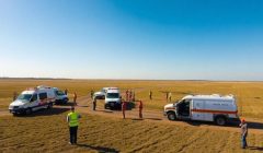 Équipes d'urgence en exercice dans un paysage rural.