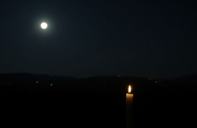 Ville sombre sans électricité, bougie éclairant la nuit.