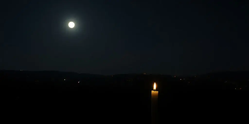 Ville sombre sans électricité, bougie éclairant la nuit.