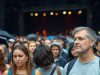 Foule de fans déçus sous la pluie.