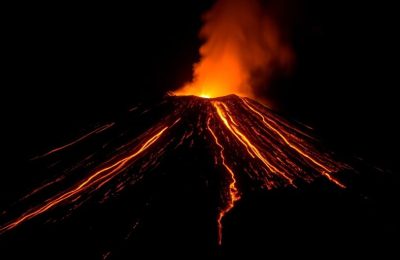Éruption volcanique nocturne avec lave orange incandescente