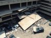 Vue aérienne du parking effondré, voitures endommagées, décombres partout.