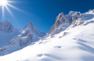 Sommet alpin enneigé en juillet avec ciel bleu