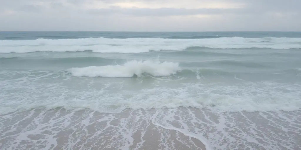 Vague puissante frappant une plage désertée par la houle.