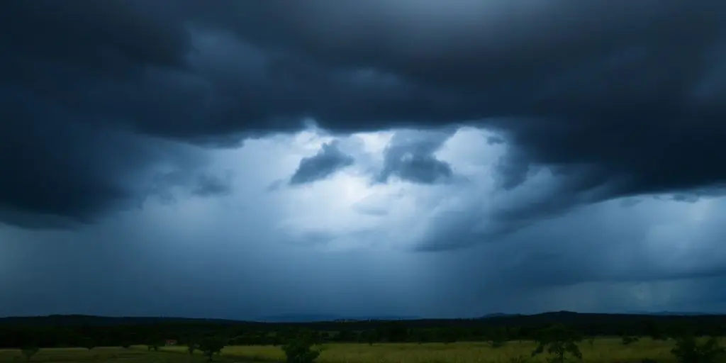 Ciel orageux avec pluie intense sur un paysage.