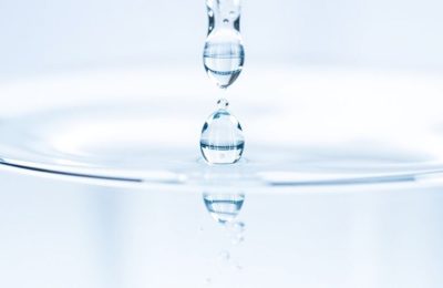 Gouttes d'eau cristallines tombant dans un récipient transparent.