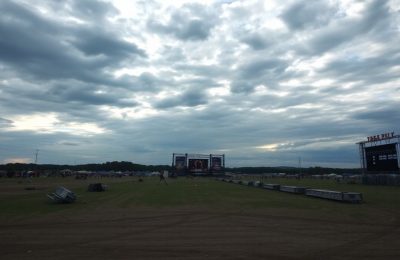 Scène vide de festival sous un ciel sombre.