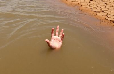 Enfant pleurant au bord d'une rivière agitée.