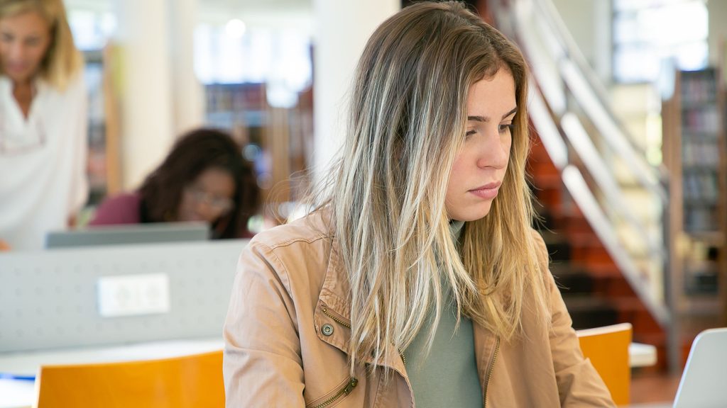 Étudiante en bibliothèque préparant sa mobilité après Parcoursup