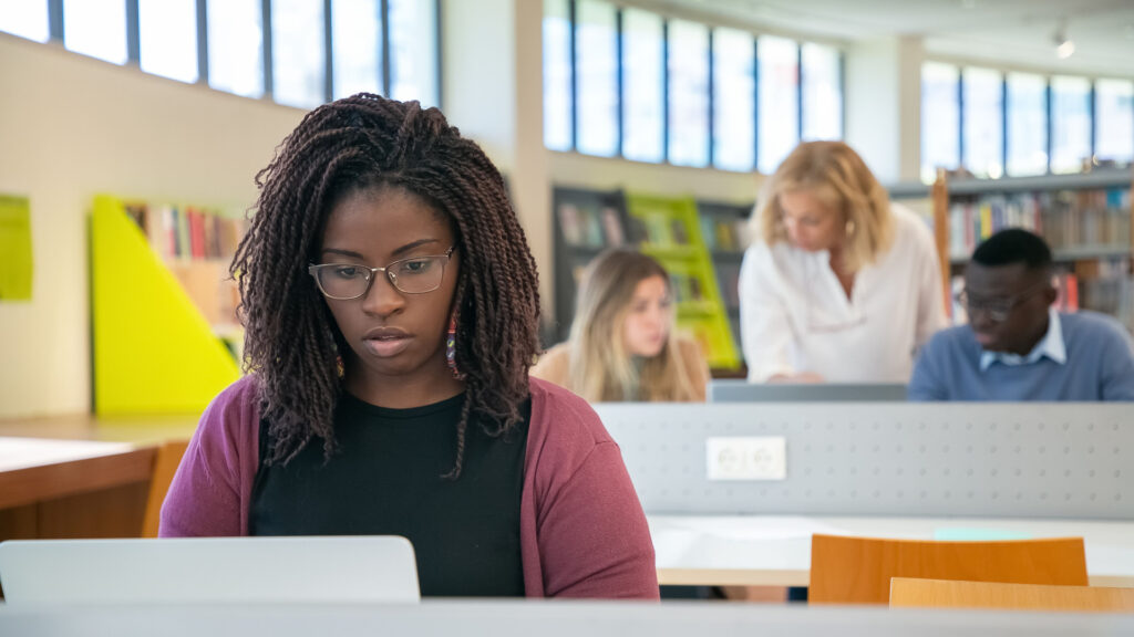 Étudiante boursière travaillant sur ordinateur avant un changement d’académie