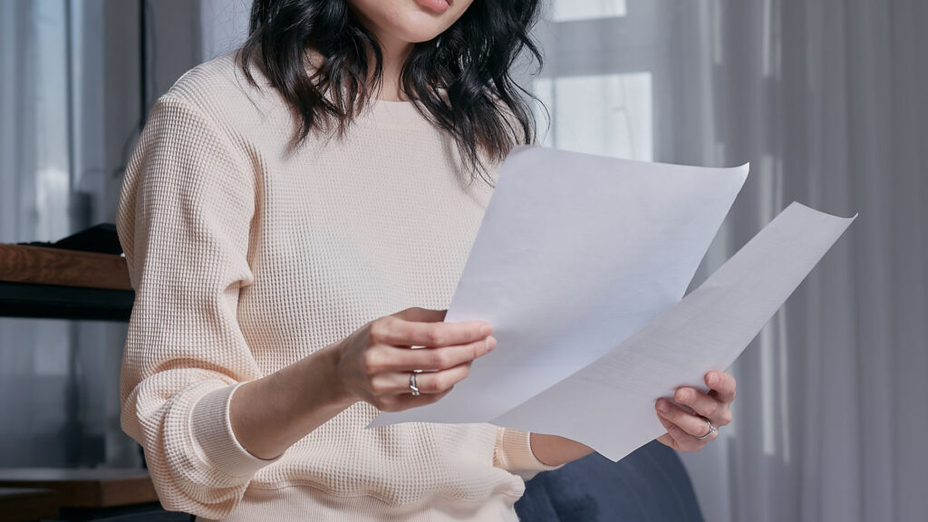 Femme étudiant ses ressources pour calculer le montant de l’allocation veuvage