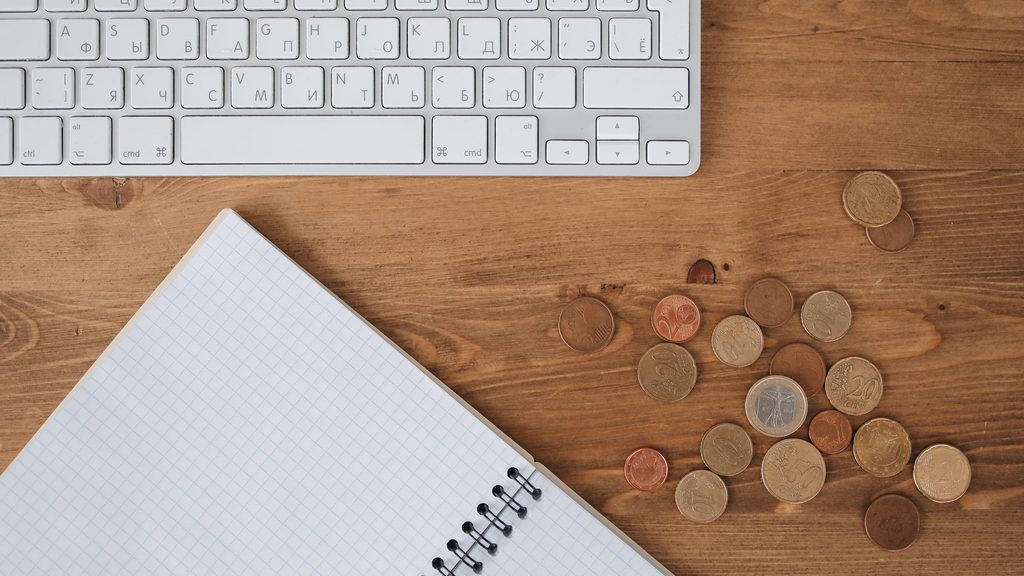 Pièces en euros et ordinateur illustrant un retard de paiement IFI