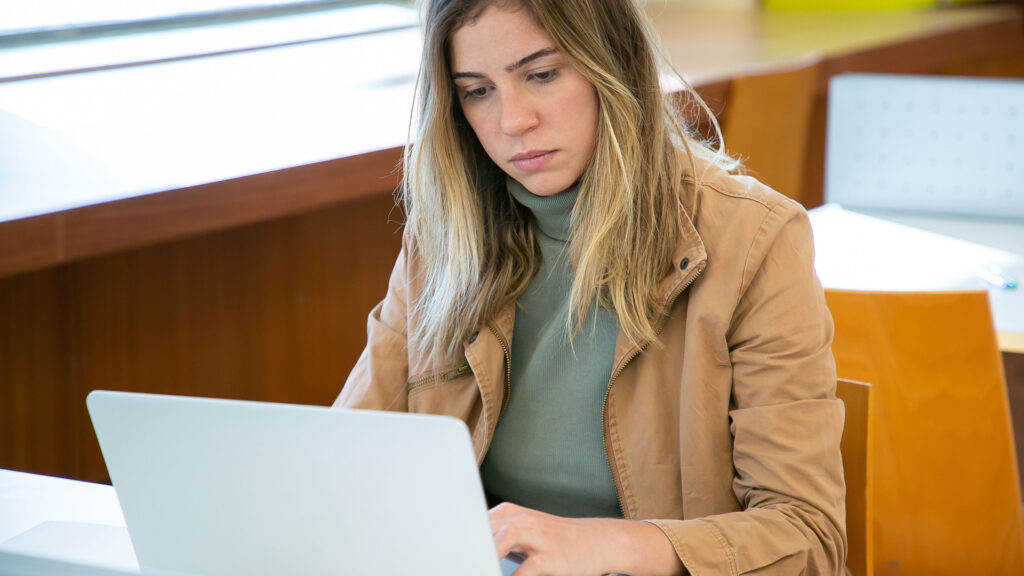 Étudiante sur ordinateur préparant son inscription administrative