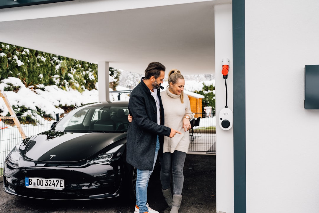 Couple rechargeant une voiture électrique à domicile