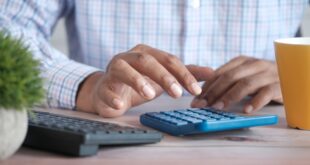 Main utilisant une calculatrice pour estimer la décote de l’impôt 2026