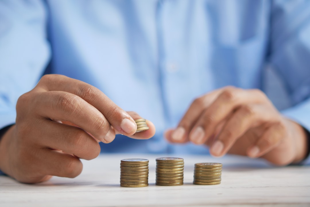 Personne empilant des pièces pour suivre son épargne bancaire