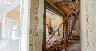 Un bâtiment en cours de rénovation montre une partie dégradée et une partie restaurée