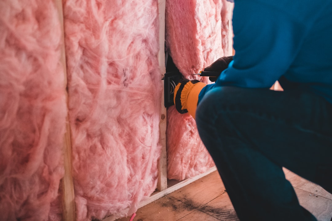 Artisan installant des équipements dans un mur isolé