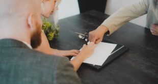 Couple signant des documents pour la vente d’un logement financé par un PTZ