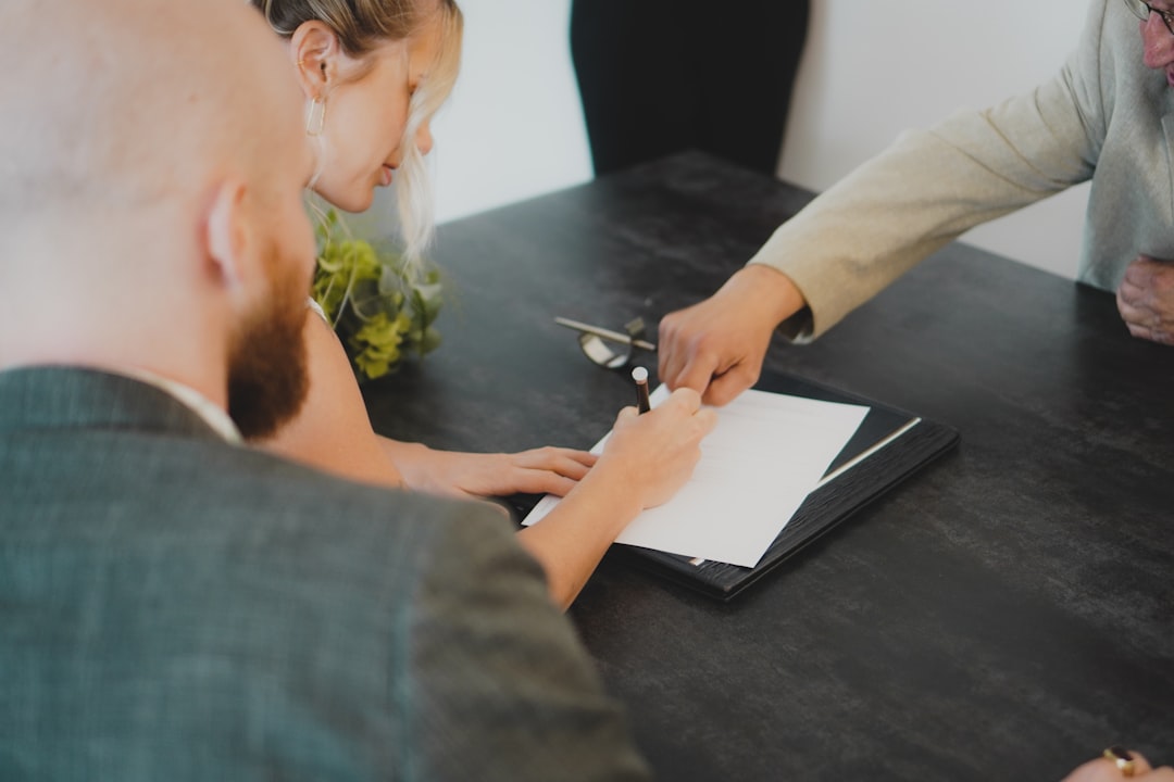 Couple signant des documents pour la vente d’un logement financé par un PTZ