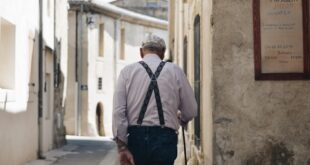Un homme âgé marche dans une rue après son départ à la retraite