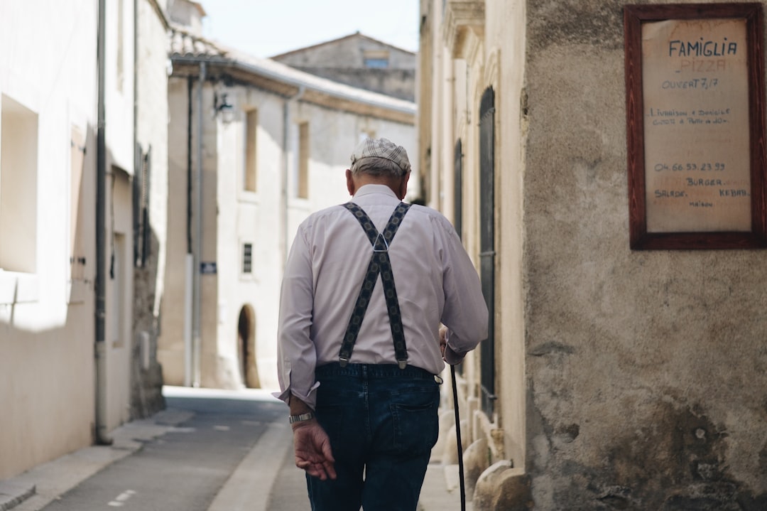 Un homme âgé marche dans une rue après son départ à la retraite