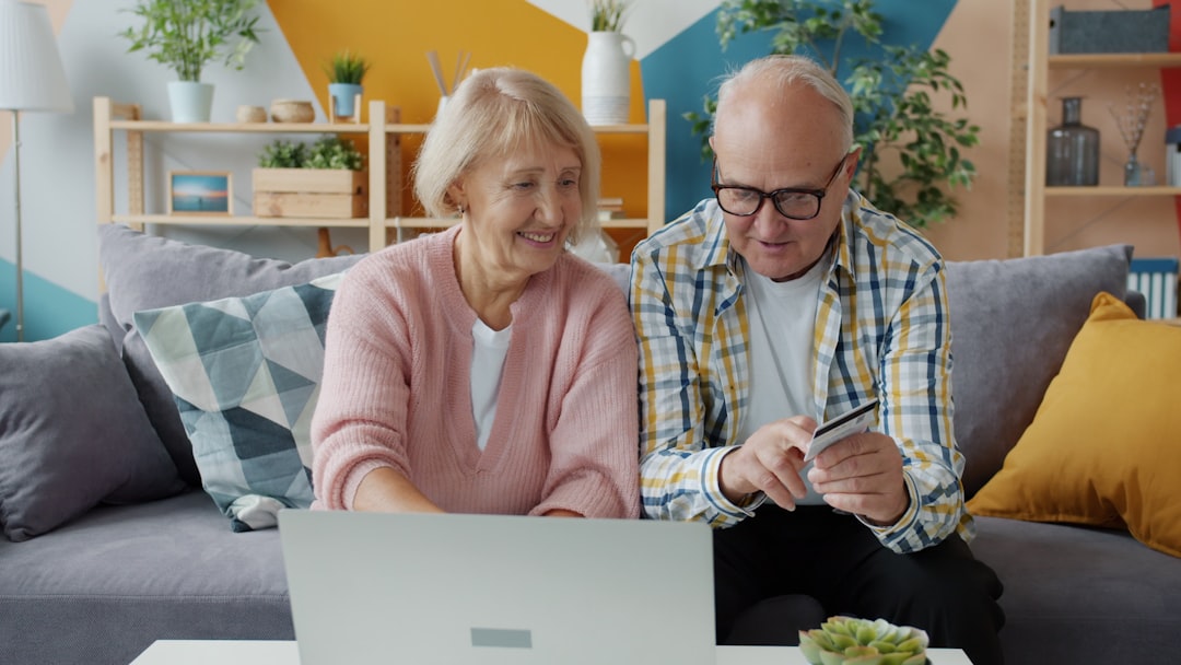 Couple de seniors contrôlant un paiement en ligne sur un ordinateur