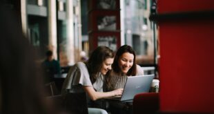 Deux étudiantes travaillent ensemble sur un ordinateur dans un café