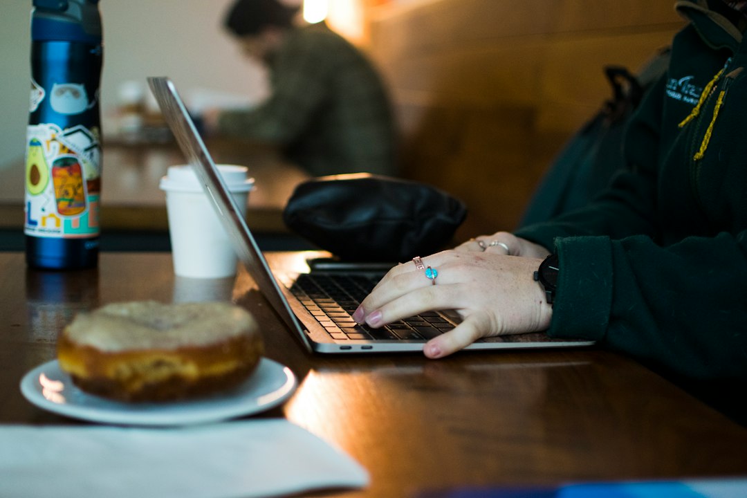 Un étudiant utilise son ordinateur portable à une table