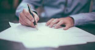 Une personne signe des documents liés à une succession