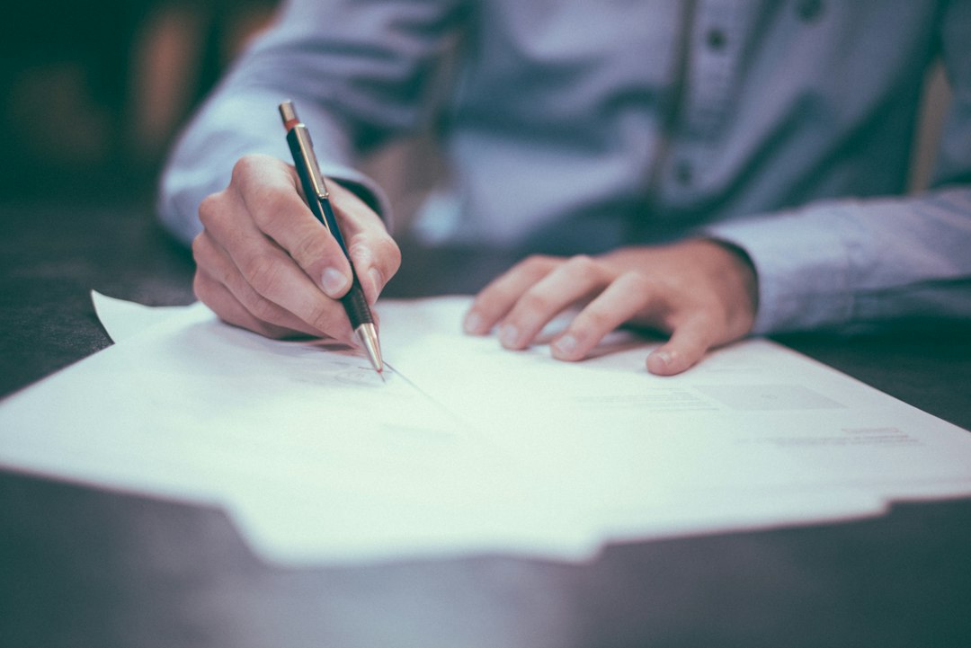 Une personne signe des documents liés à une succession