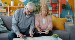 Couple de seniors consultant des factures et documents fiscaux à domicile