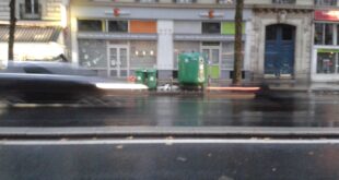 Poubelles devant des immeubles dans une rue parisienne