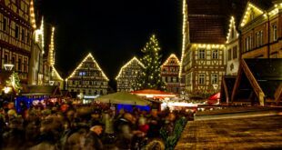 Chalets illuminés d'un marché de Noël à la tombée de la nuit