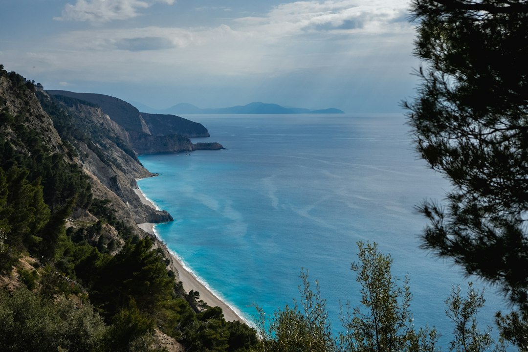 Plage de sable et eau turquoise au pied de falaises
