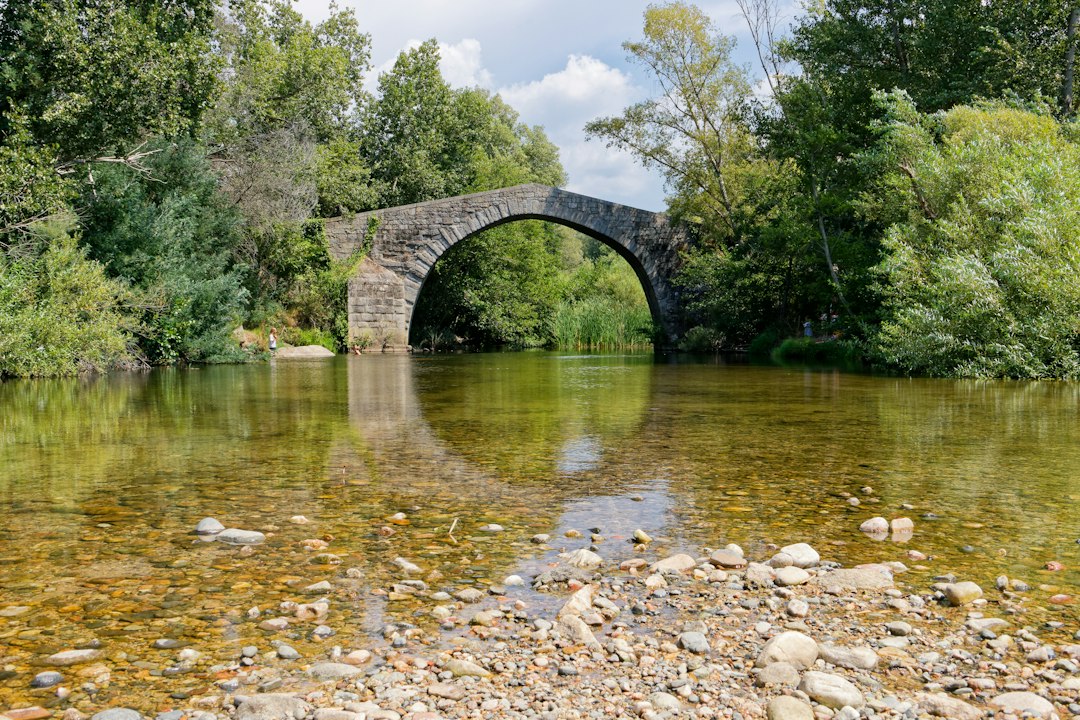 Pont de pierre au-dessus d'une rivière, paysage typique des véloroutes